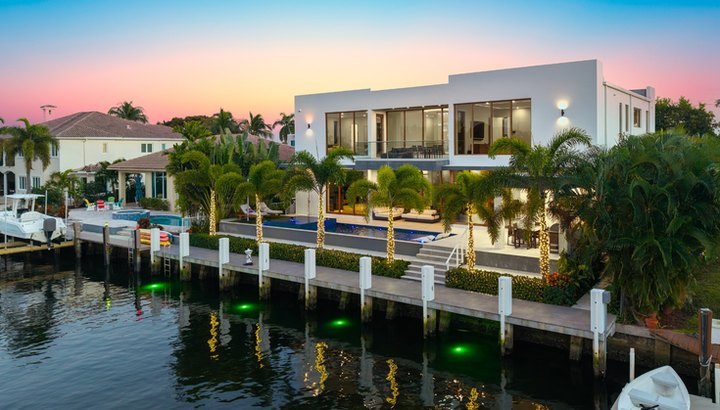 Contemporary waterfront estate and private dock at dusk