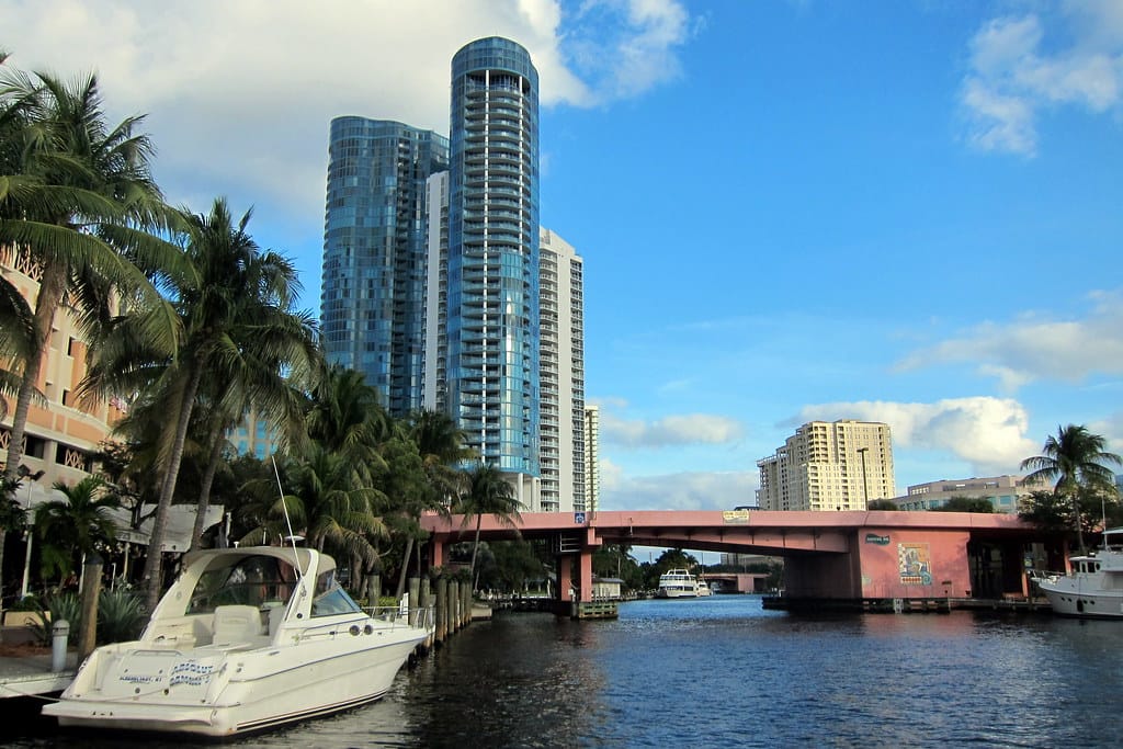 The New River in downtown Fort Lauderdale, with a docked boat, palms and high-rise towers along the bank